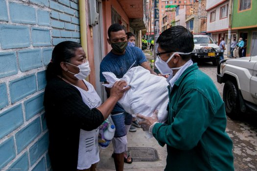 Mujer recibe en la puesta de su casa mercado