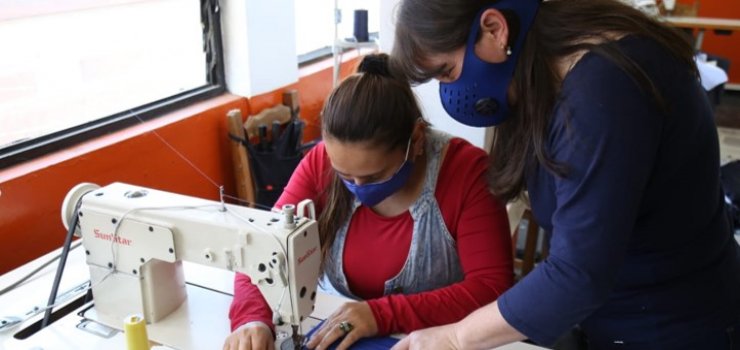 Foto de dos mujeres en una maquina de coser Este 1 de mayo se conmemora el Día Internacional del Trabajo