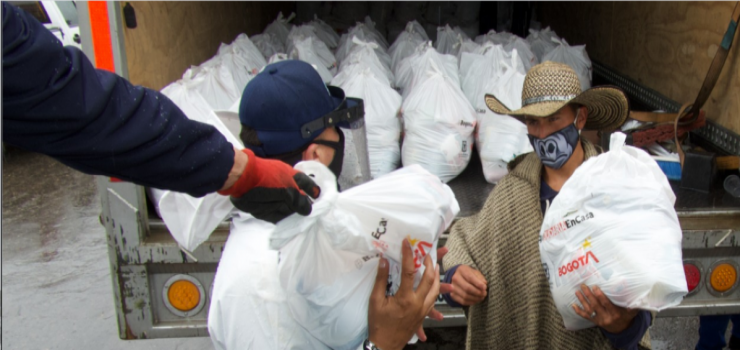 Foto de campesino recibiendo una bolsa con mercado