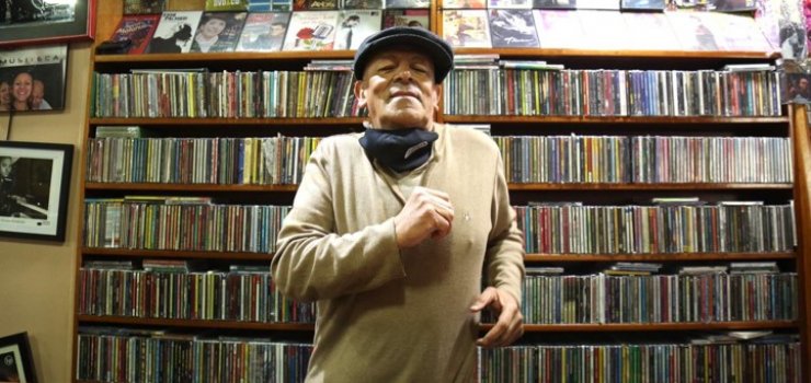 Fotografía de persona mayor frente de estantería con discos en cd. Musiteca, un lugar en el corazón.